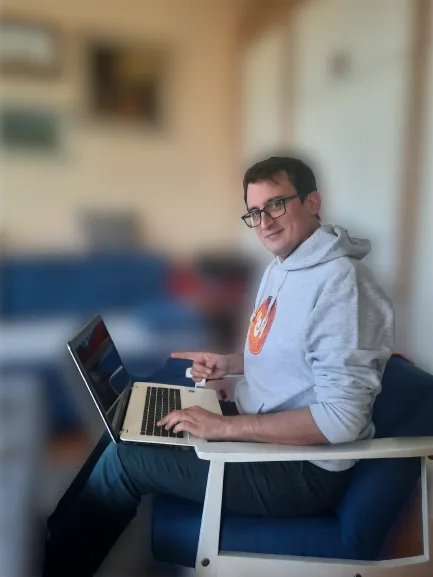 Filip Dorić presenting SFT21 Business Concept and Vision on laptop(2) Filip Dorić sitting and showing a laptop with the message "SFT21 Business Concept and Vision – Building a Global Online Community"